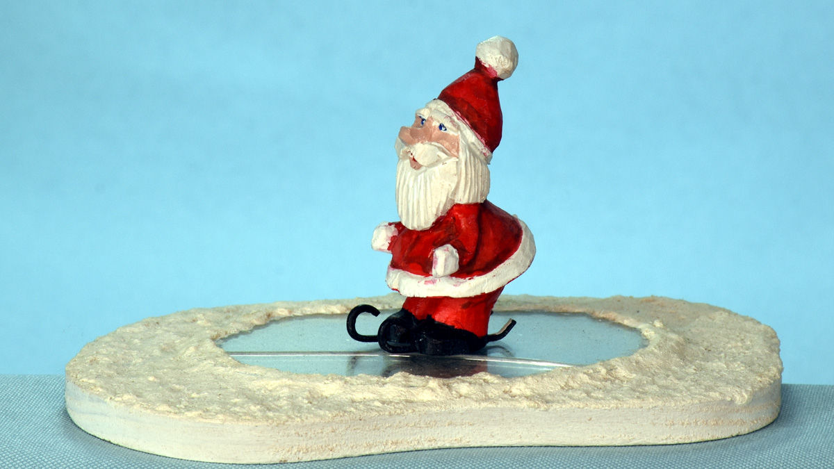 Santa is skiing on ice, carved and painted by Al Furtado.