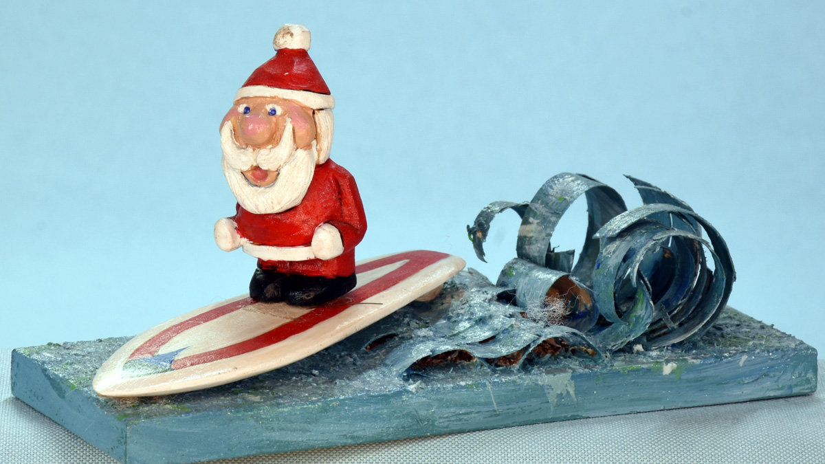 Santa is surfing the waves carved and painted by Al Furtado.