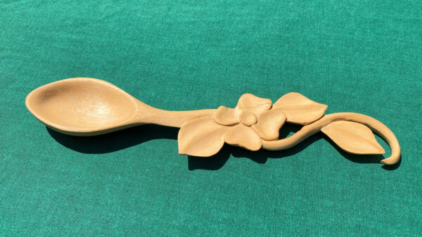 A decorative spoon featuring a flower carved by Alan Huntzinger.