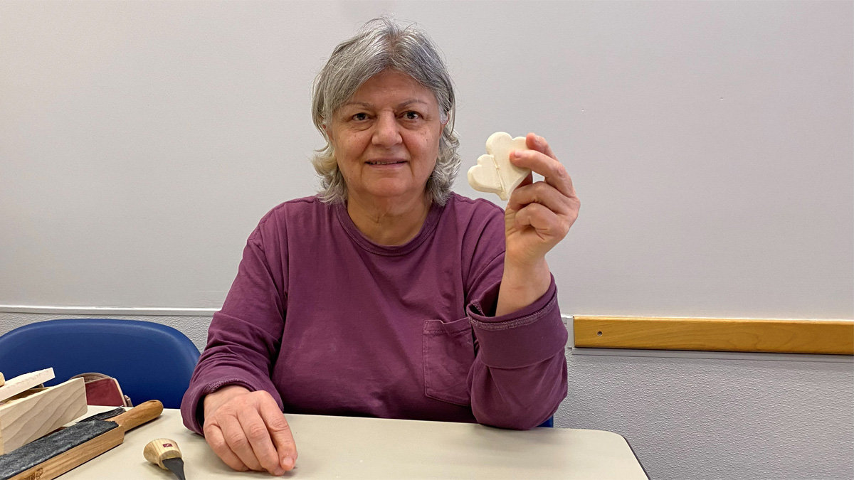 Ashraf shows two hearts joined that she carved from basswood.