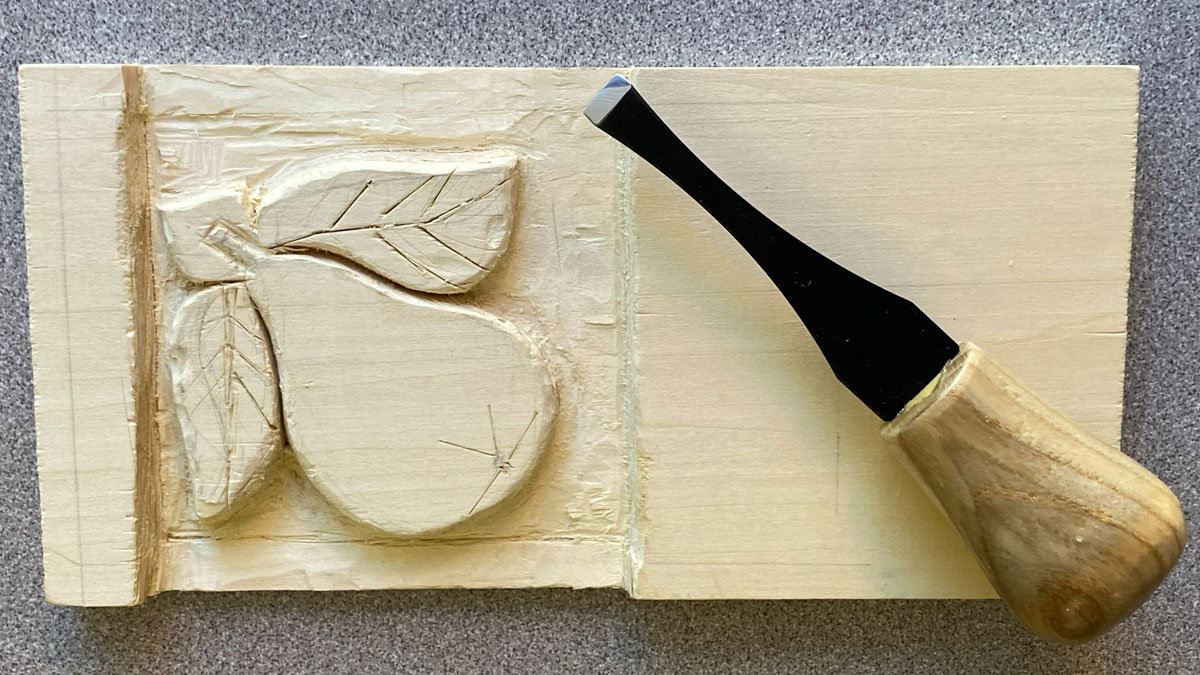 A pear carved on a basswood board with a gouge.
