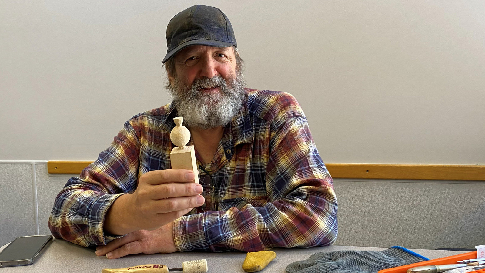 Bill Peekema holds a small basswood woodcarving project featuring a sphere atop a rectangular block (future carved pumpkin).