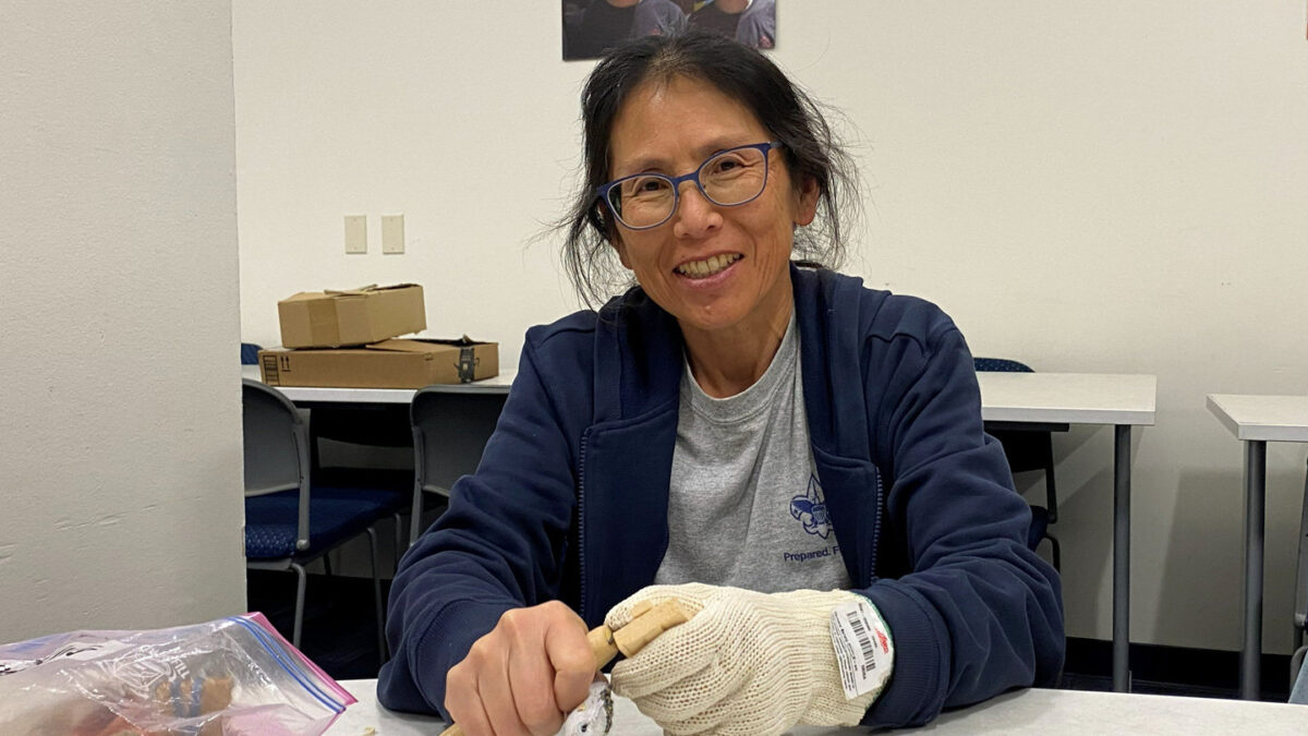A fellow carver is whittling a wooden chain at the Santa Clara Valley Carvers meeting on Thursday in spring 2026.