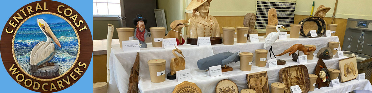 A logo of Central Coast Woodcarvers and shelves of woodcarving projects at the club's woodcarving show in 2025.