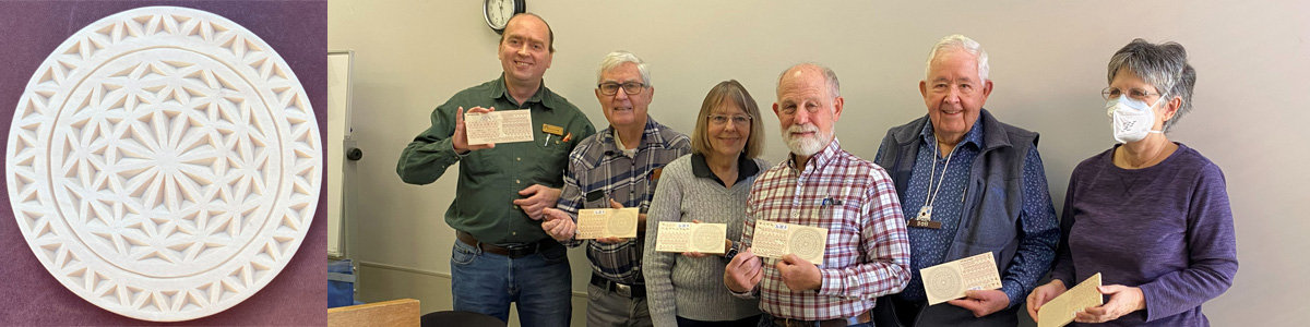 A photo of a round "Supernova" chip carved coaster and SCVC club members holding their chip carving boards. The image captures a chip carving workshop taught by Roman Chernikov in 2023. Visit Roman's website, READ N TRY, for chip carving practice boards: https://readNtry.com