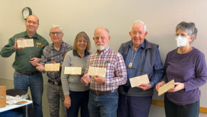 Chip carving workshop participants happily showing off their chip carving practice boards.