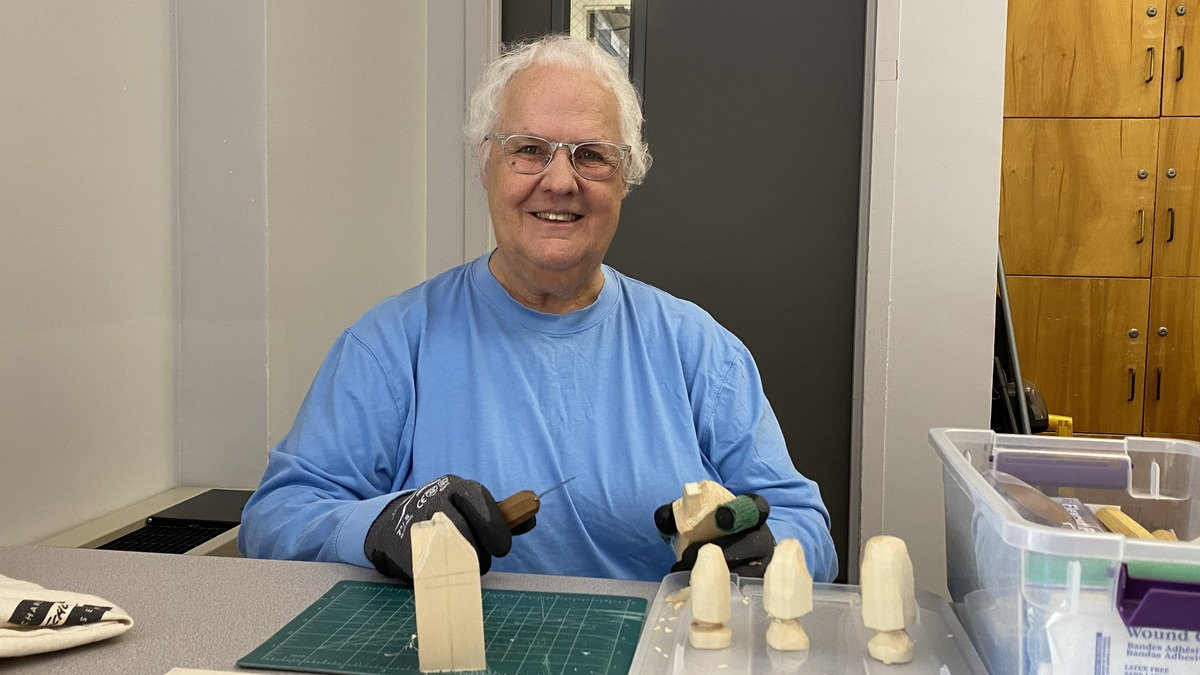 Connie Wilson smiles while carving wooden ghosts and a small house during a Santa Clara Valley Carvers meeting at the Los Gatos Adult Recreation Center.