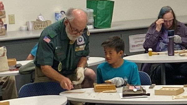 Dan Brady teaches Cooper how to sharpen a carving knife.