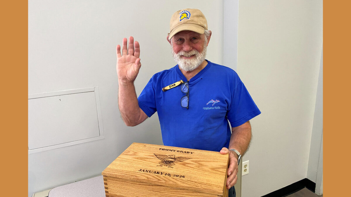 Dan Brady, secretary of Santa Clara Valley Carvers, holds a handcrafted oak box he built for his grandchild, Tommy Brady, featuring an engraved eagle and anchor design.