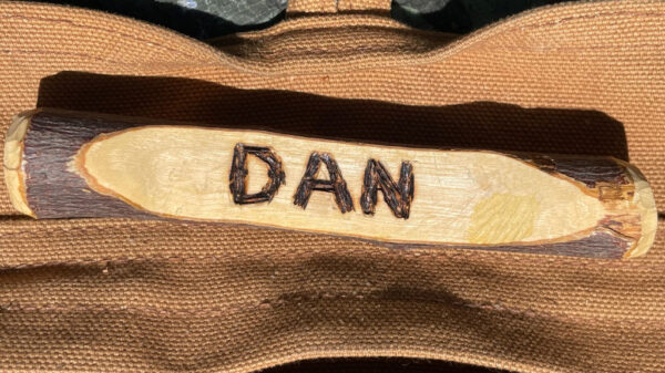 A minimalist name badge whittled from a stick.