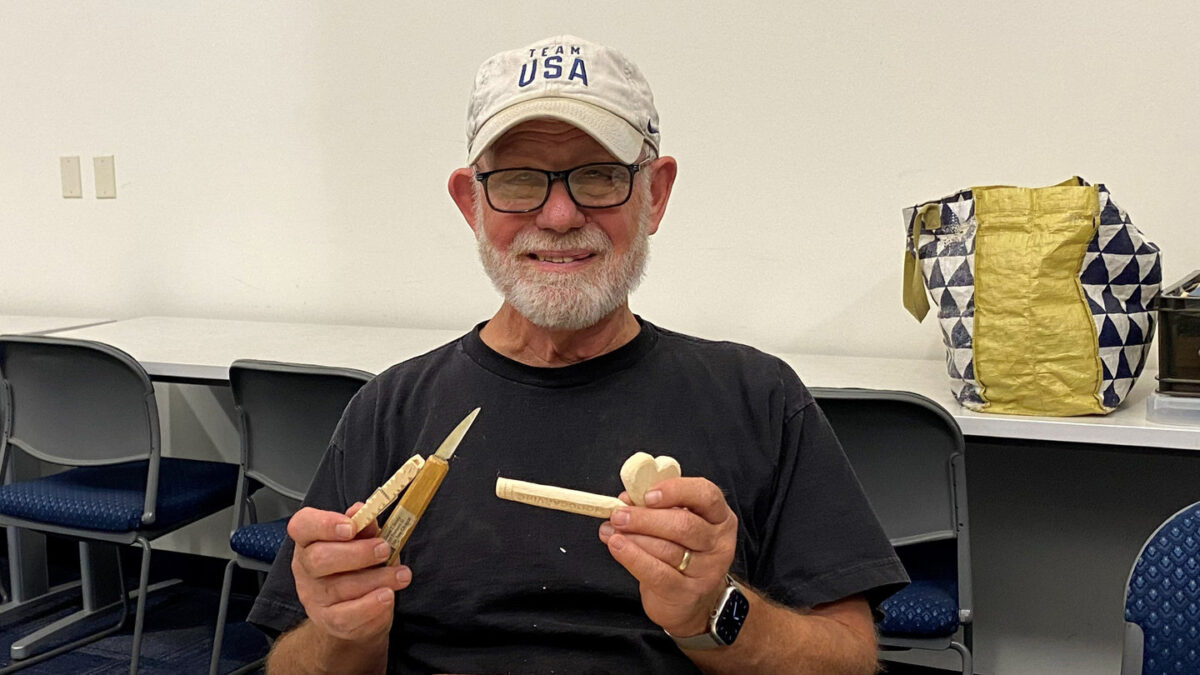 Dan Brady holds several carvings and a carving knife.