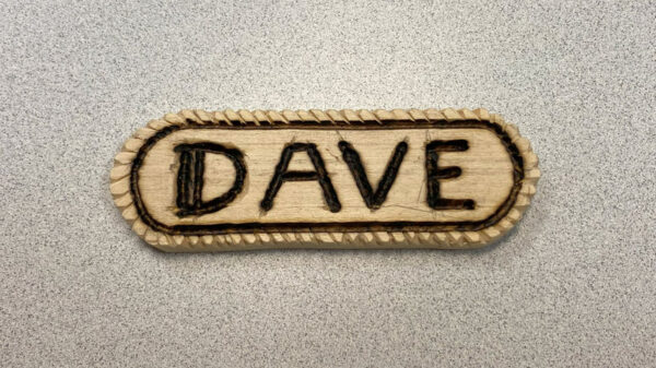 A name badge with the rope effect carved around the perimeter.