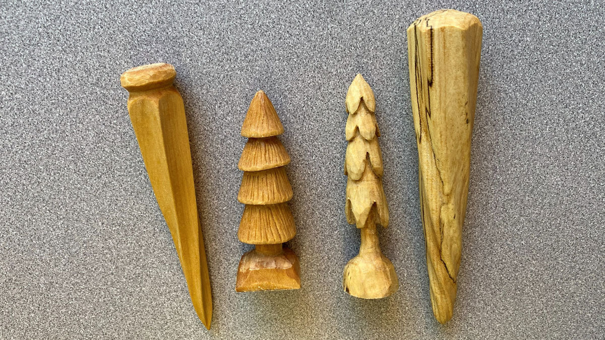 Two carved icicles and two small trees carved from basswood and finished with oil. They are 3-6" long.
