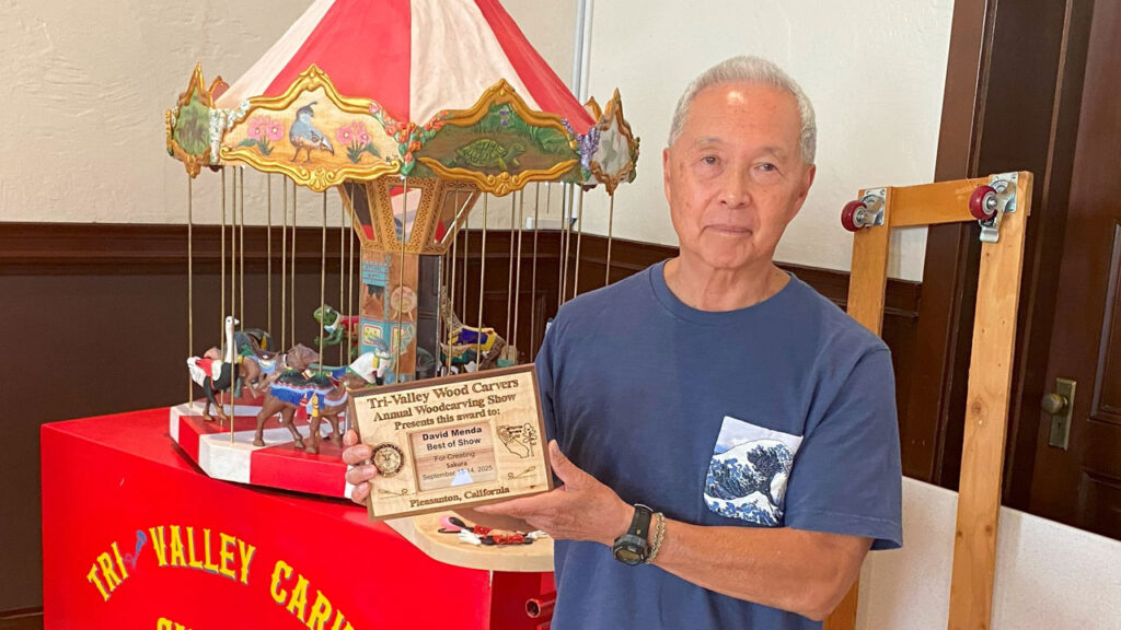 David Menda shows his plaque for winning the best of woodcarving show award for his "Sakura" woodcarving in Pleasanton, CA, September 2025.