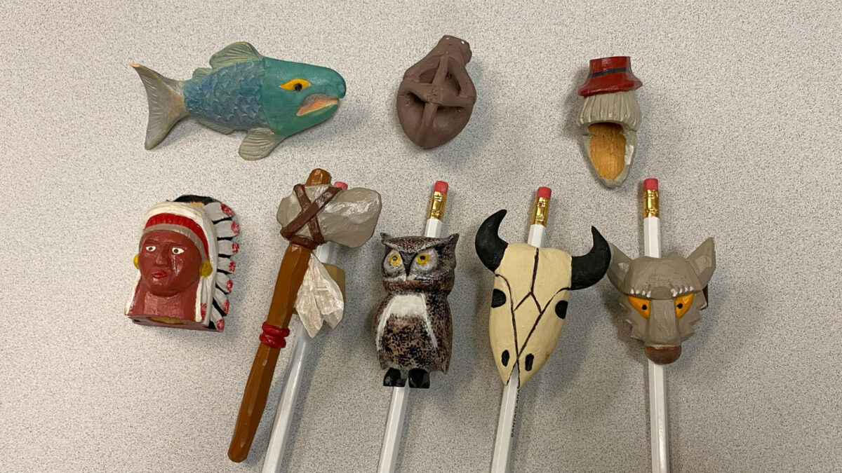 Eight colorfully painted neckerchief slides carved from basswood.