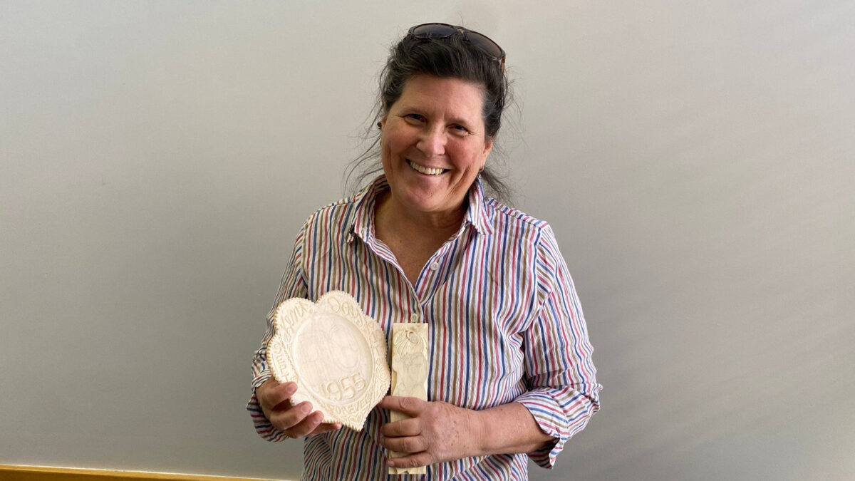 Dawn Anderson displays two woodcarving projects in progress, including a heart-shaped plaque and a ghost relief, during a Santa Clara Valley Carvers meeting at the Los Gatos Adult Recreation Center.