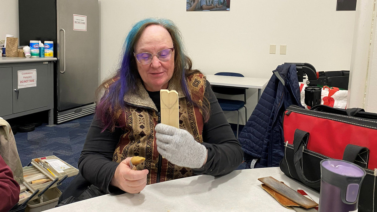 Debbie is carving a simple heart from basswood.
