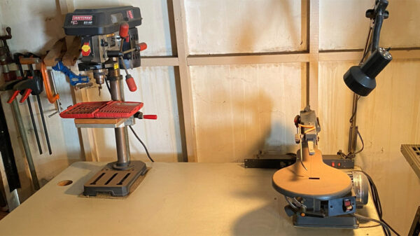 A bench with a drill press and a scrollsaw.