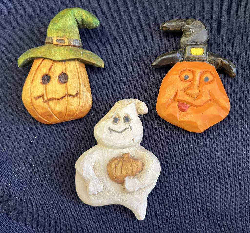 The picture shows wooden pumpkins in hats and a ghost with a pumpkin. This is a project for woodcarving class on wooden pumpkin carving.