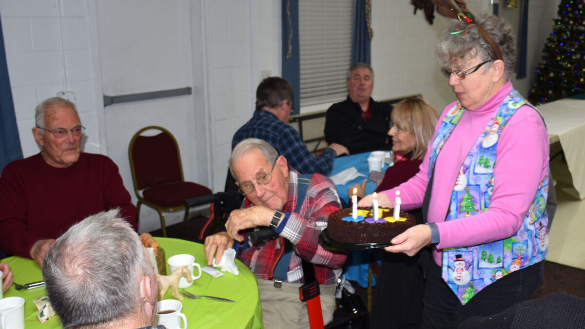 Joanne Carroll presents Jack Thompson with a birthday cake with 101 candles.