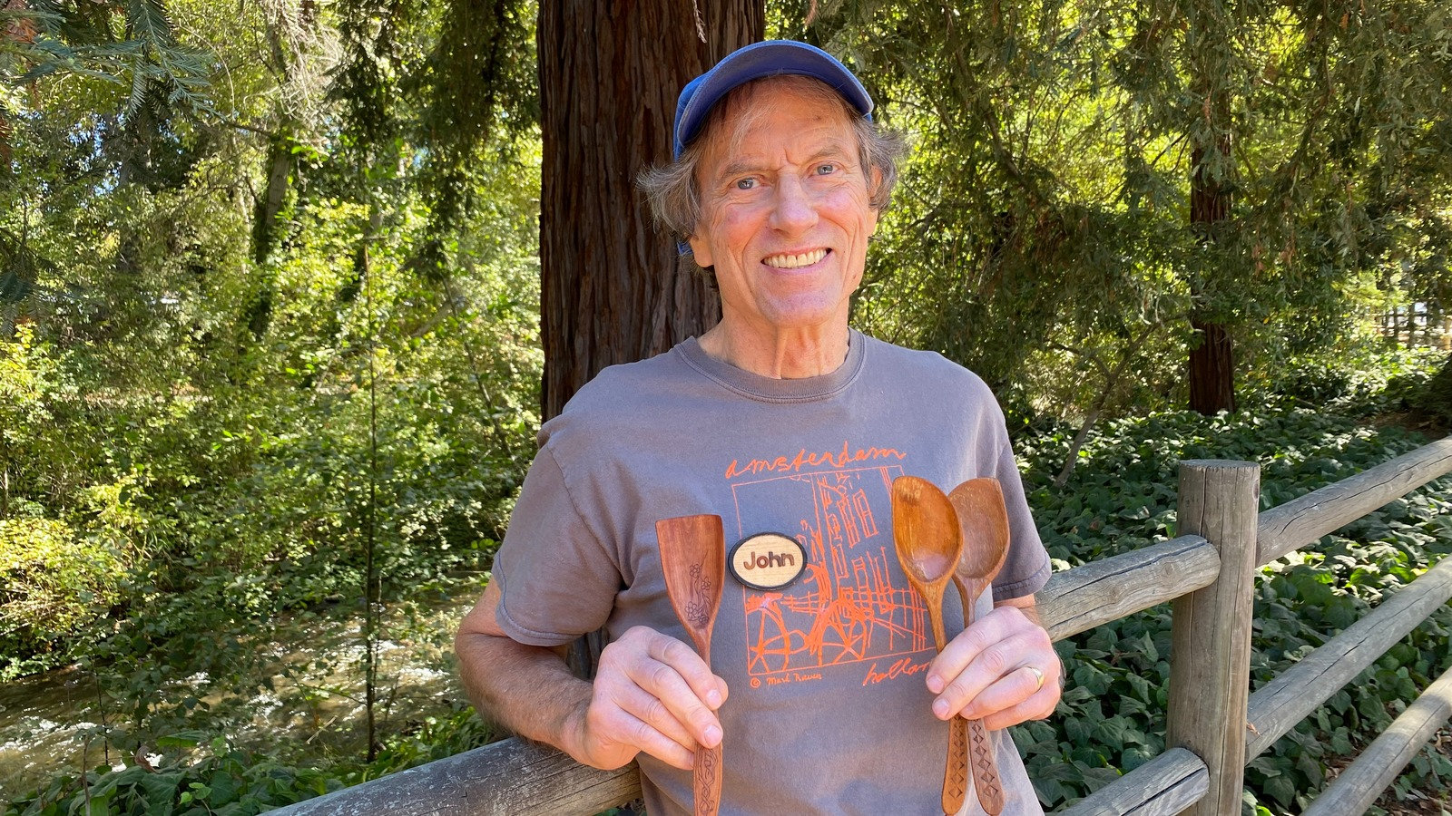 Professional woodturner John Wells holds three hand-carved wooden spoons featuring kolrosing and chip carving techniques during a demonstration for the Silicon Valley Woodturners.
