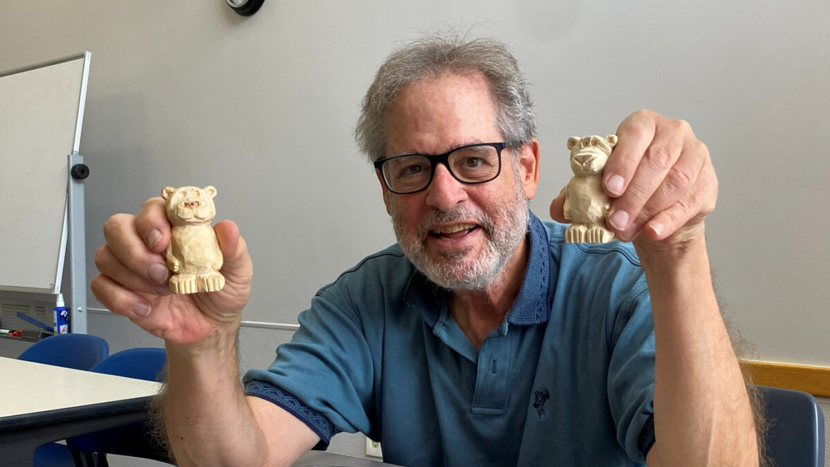 Jonathan Jackel holds up two small carved basswood bears.