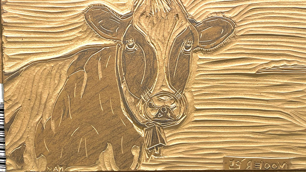 A carved linoleum block with a cow design. The photo was taken for the SCVC woodcarving newsletter.