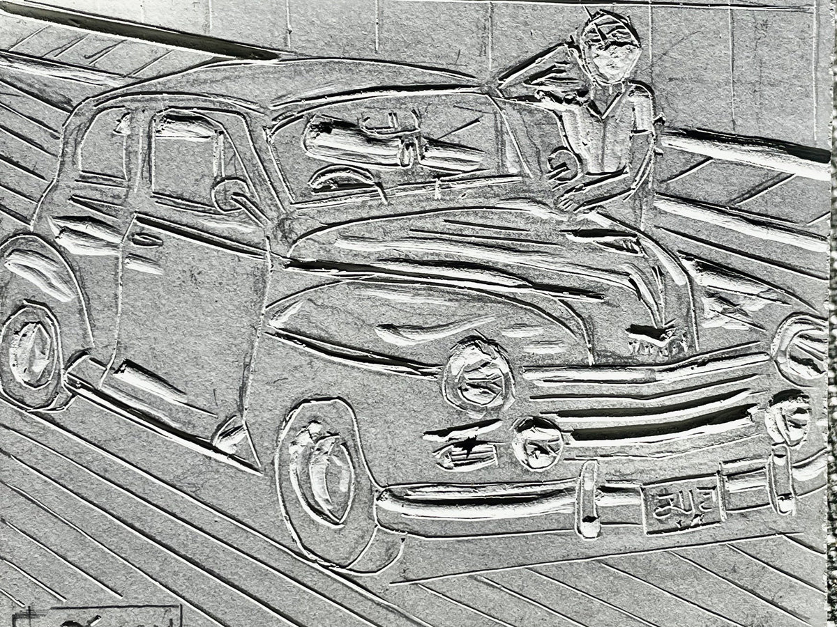 A partially carved linoleum block depicting a vintage sedan, identified by the filename as a Plymouth Deluxe, angled toward the right. A figure leans casually against the hood of the car, looking upward with one hand near their head. The vehicle features prominent rounded fenders, large headlights, and horizontal grille slats, with a license plate reading "5115" visible on the front bumper.