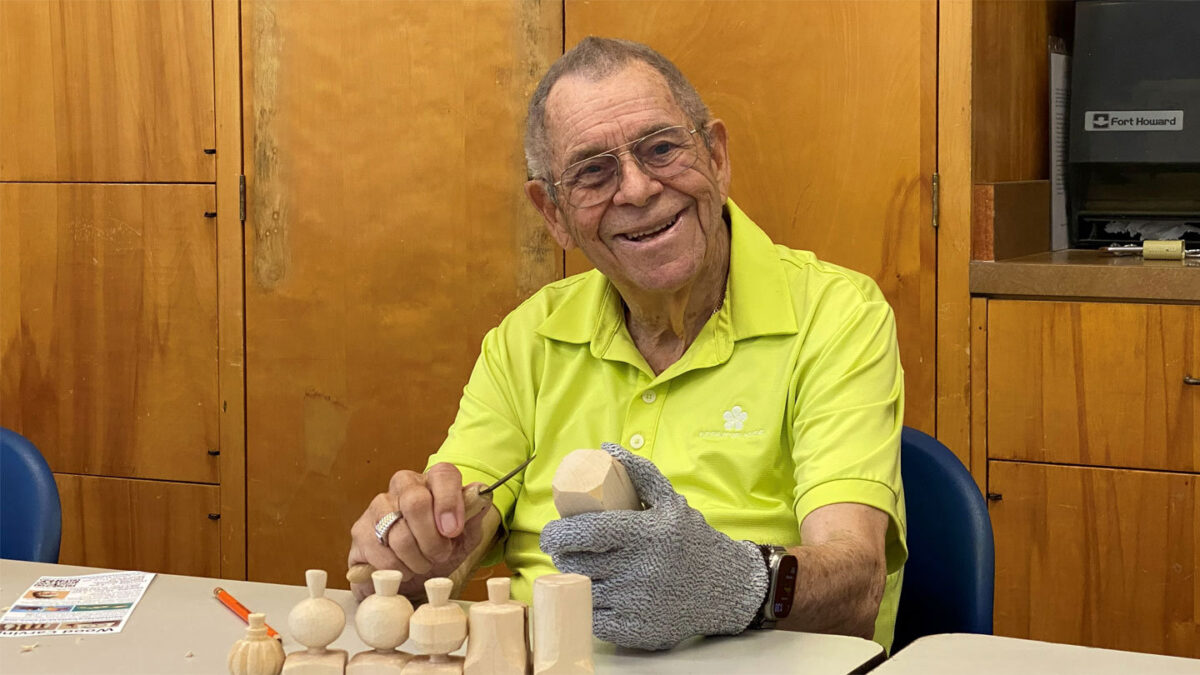 Michael Butcher carves a wooden pumpkin using a carving knife and protective glove at a Santa Clara Valley Carvers meeting in Los Gatos, CA.