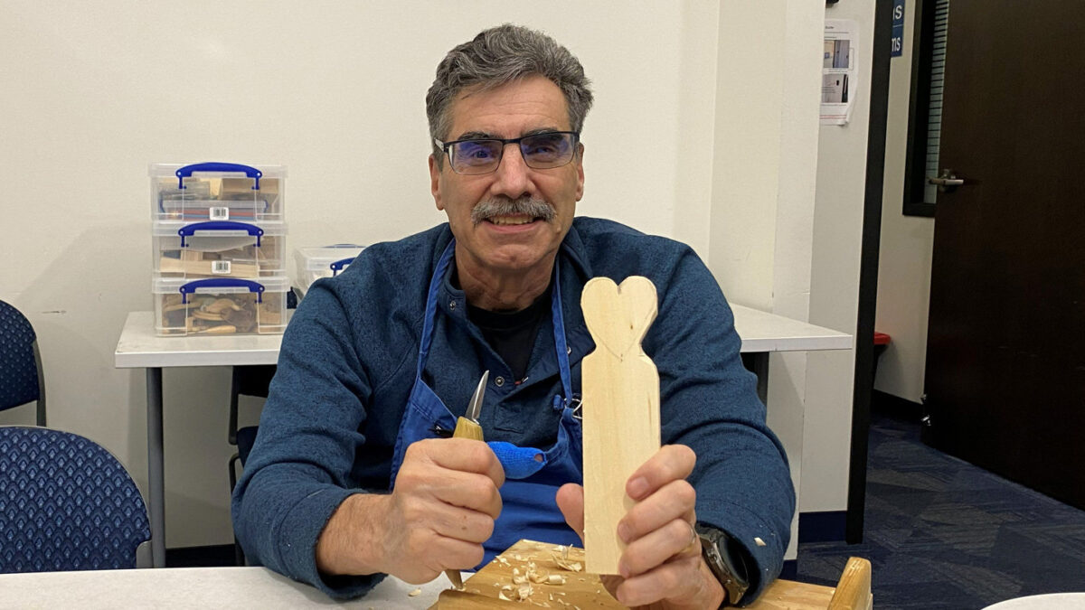 Mike shows his carved heart as he whittles it.
