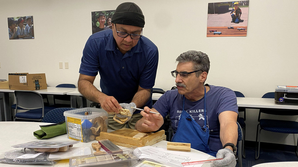 Nitin and Mike are discussing ways to carve a wooden chain.