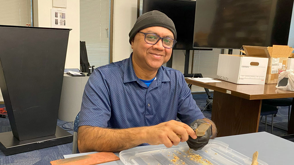 Nitin Varshney is carving a butter spreader from a piece of basswood. He joined the Santa Clara Valley Carvers in May 2025.