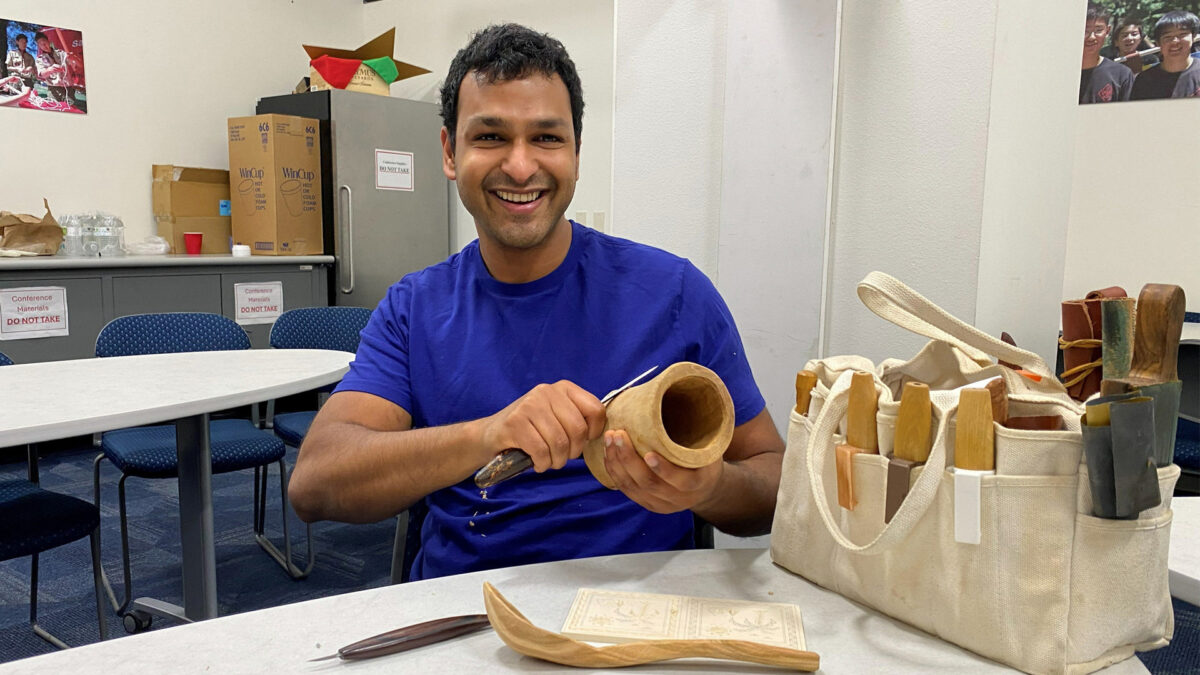 Pranay is carving a shrink pot from freshly cut wood.