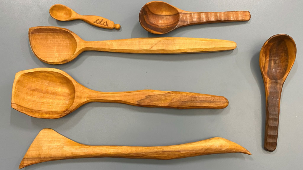 Five hand-crafted wooden spoons from apple and walnut wood. The photo also includes a spatula.