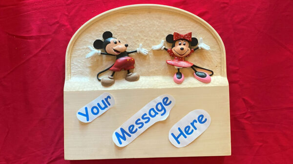 A welcome sign carved by Ken Morgan: Mickey and Minnie dance