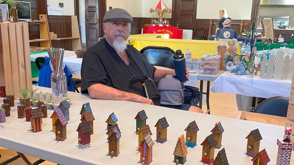Richard Riley set up a table filled with carved miniature houses at the TVC Woodcarving Show in September 2025 in Pleasanton, CA.