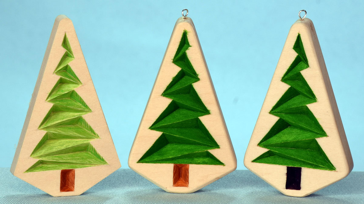 Three small chip carved firs based on the Roman's pattern he shares on his website READ N TRY (https://readNtry.com), along with other free chip carving patterns.