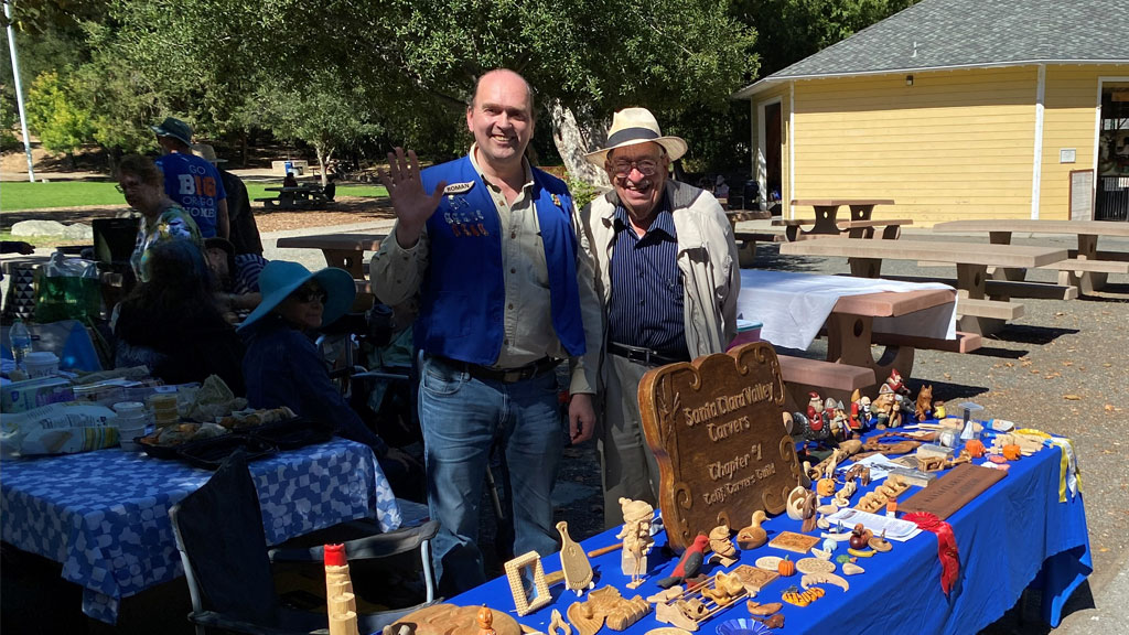 Roman and Jordan welcome visitors to review our woodcarving projects on display at the local park.
