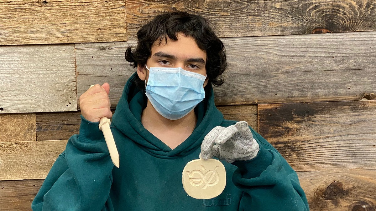 Sanjay Tirumalai holds a carved wooden letter opener and basswood disc he created during a Santa Clara Valley Carvers meeting at the Scouting America office in San Jose.