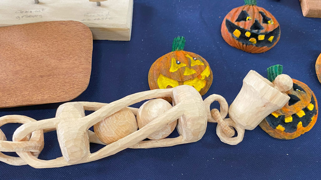 A whittling chain with a ball in a twisted cage and a bell with a working clapper. Carved by Scot Lang.