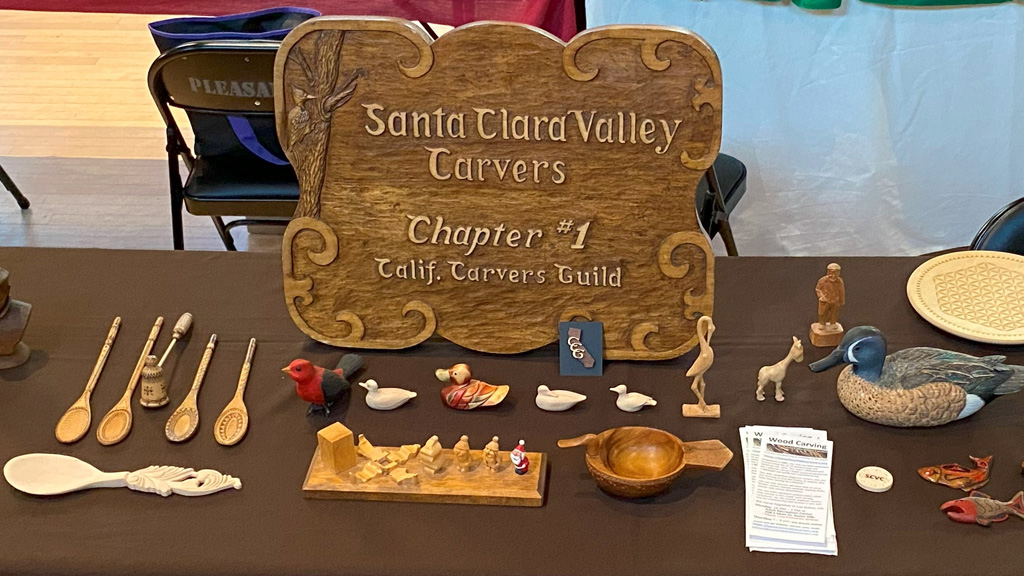 A table set up by Santa Clara Valley Carvers with carved spoons and animals.