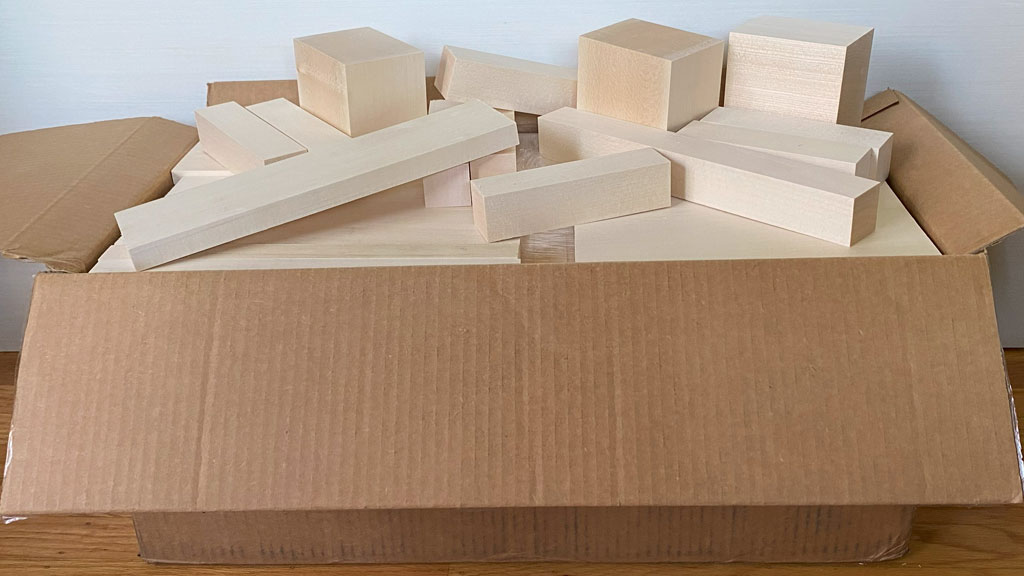 A large cartoon box full of freshly cut, kiln-dried basswood.