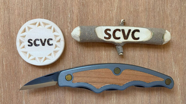 Two simple name badges and a folding carving knife.