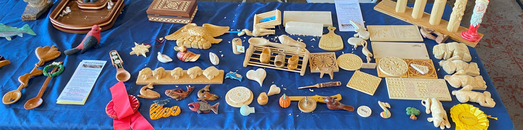 A table with dozens of small woodcarving projects.