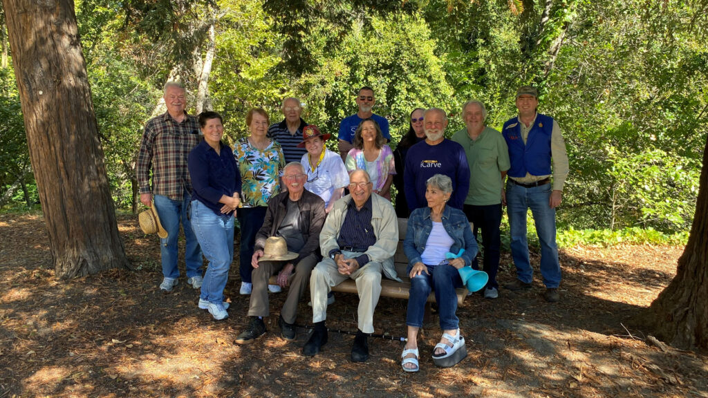 A group photo of woodcarving picnic participants.