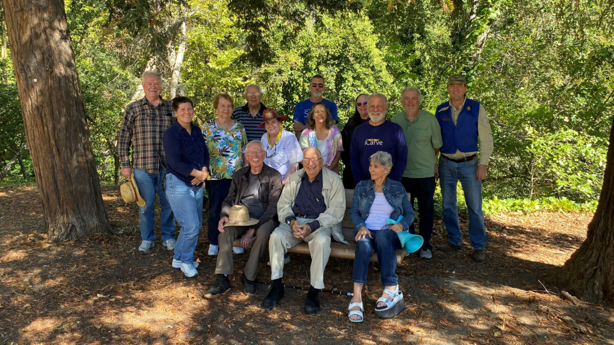 A group photo of woodcarving picnic participants.
