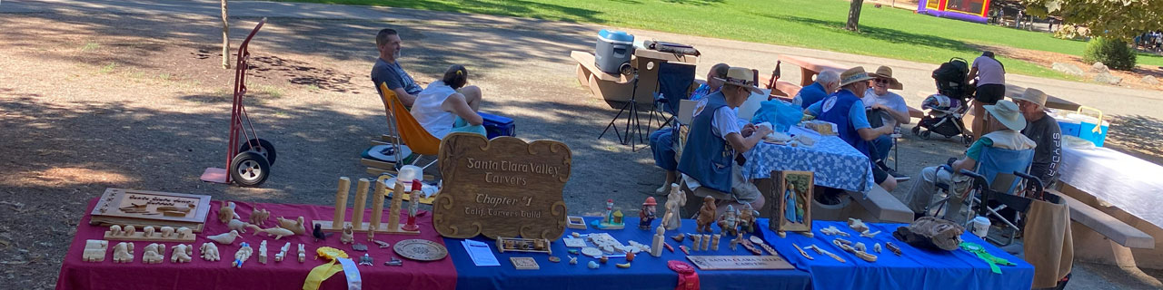 Display tables full of carvings during SCVC woodcarving picnic at Oak Meadow Park in Los Gatos