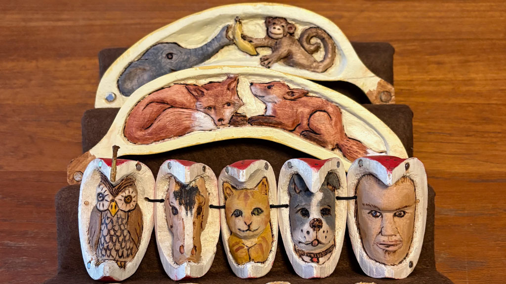 An open fruits (banana, apple) with animals carved inside by Theda Mobley