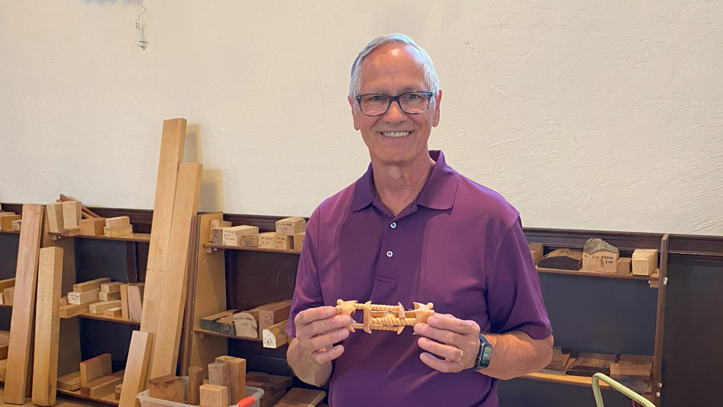 Tim Geiger holds an intricately carved ball-in-the-cage that he carved from basswood.