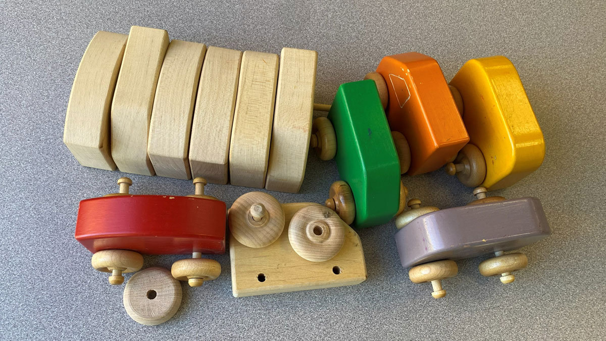 A dozen wooden blocks for making toys. A few are painted in bright colors.
